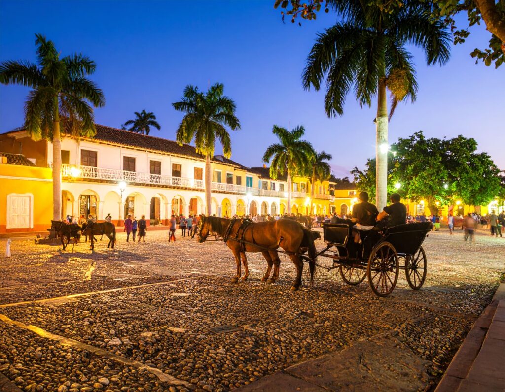 Plaza Mayor Trinidad im Abendlicht mit Kolonialbauten und Musikanten.