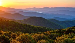 Panorama der Blue Ridge Mountains in Virginia bei Sonnenuntergang mit leuchtendem Wald und Nebel.